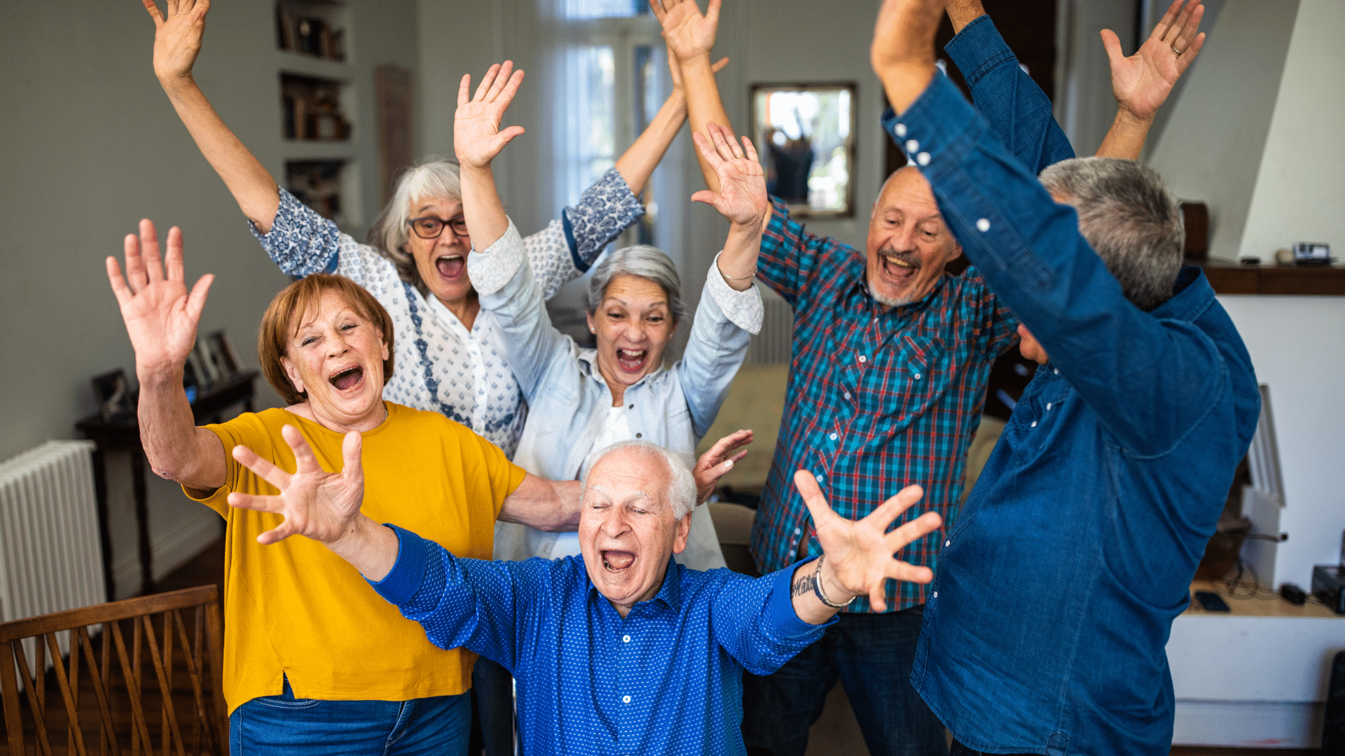 A cheerful crowd of elderly people with hands uplifted, showcasing a moment of joy and togetherness